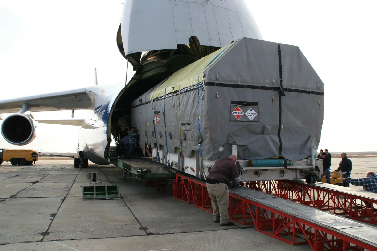 Equipe de pátio embarcando uma carga de grande porte pelo nariz de um avião cargueiro